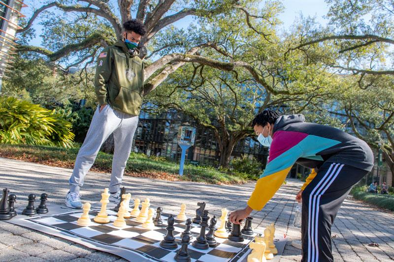 Two students participate in chess game on campus