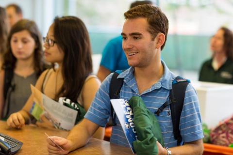 new student smiles as they check in to their new residence hall