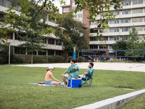 Three students sitting on quad