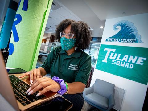 Residential life staff member works from her laptop behind desk
