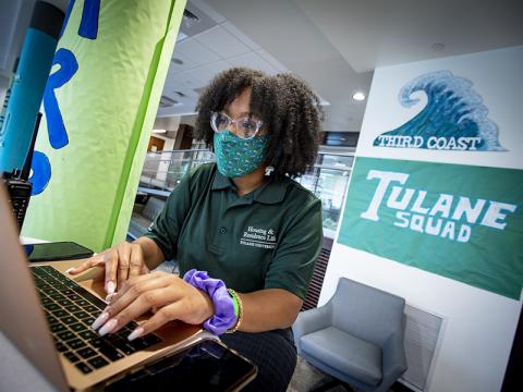 A student works from her laptop at desk