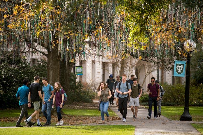 students walk across campus on a sunny day